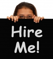 Woman peaking over a Hire Me sign